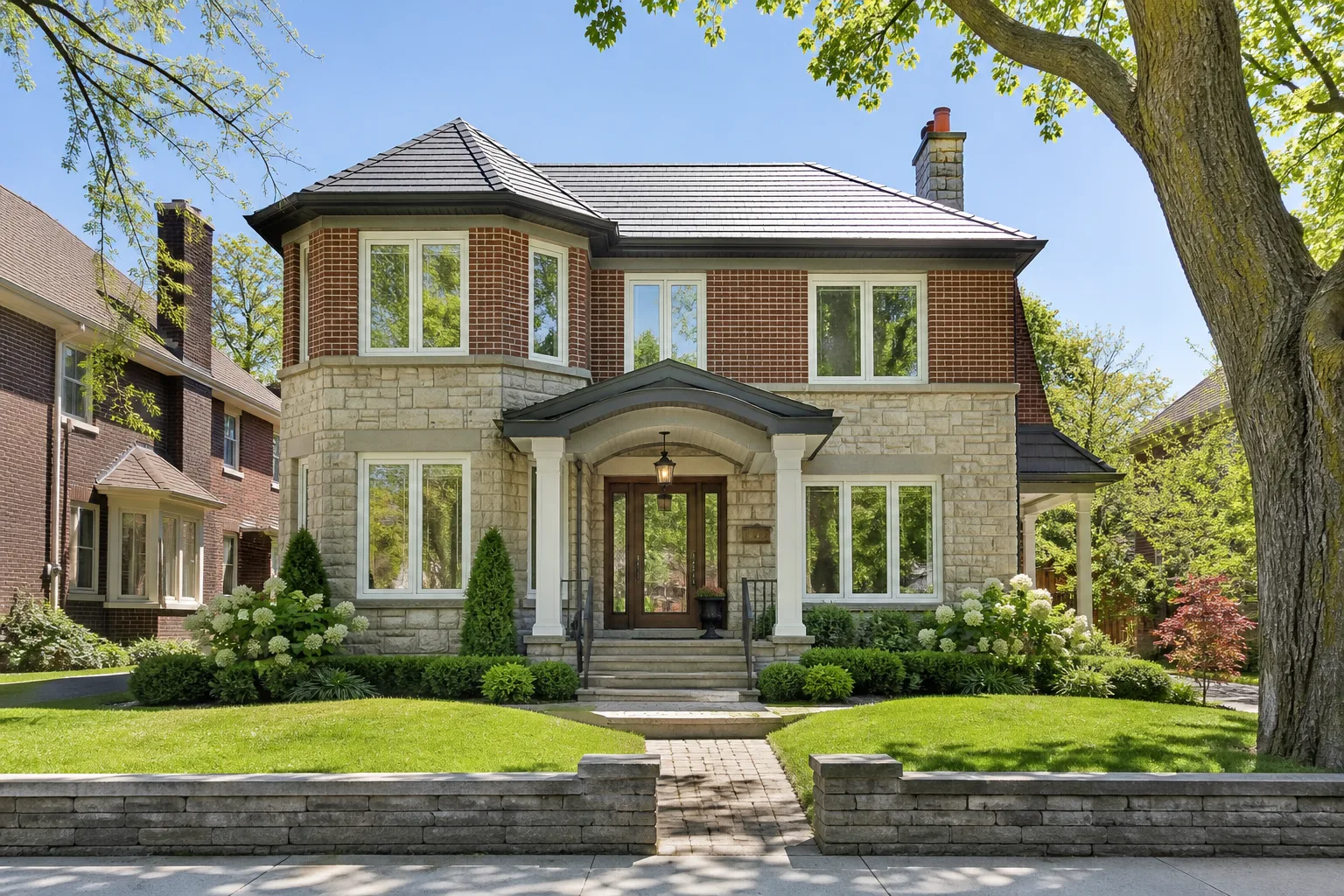 White vinyl casement windows on a two-storey brick and stone heritage home in Oakville, Ontario