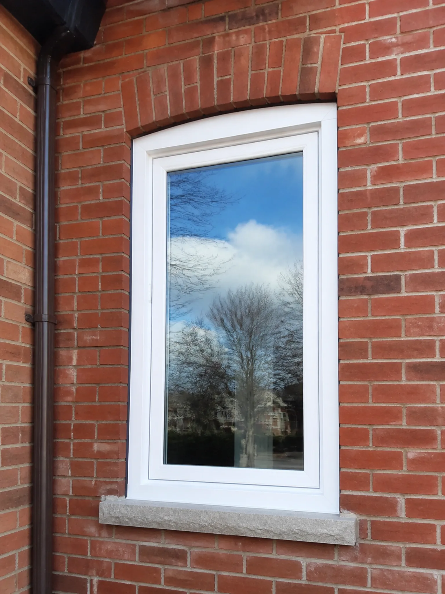 Newly installed energy-efficient vinyl casement windows on a brick Whitby home
